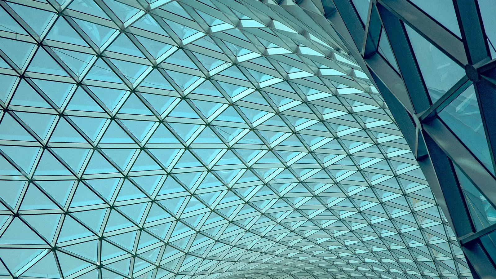 Curved glass ceiling with triangular steel framework in contemporary airport terminal building