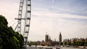 London Eye observation wheel and Palace of Westminster with Big Ben beside River Thames