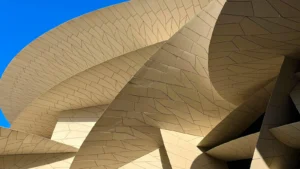 Abstract architectural close-up of beige metal cladding with sweeping curved lines