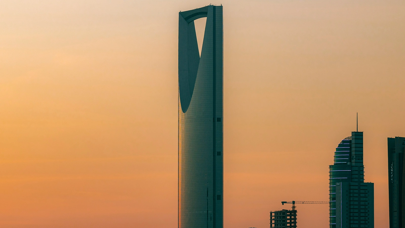 Riyadh skyline featuring Kingdom Centre Tower and modern high-rises in golden light