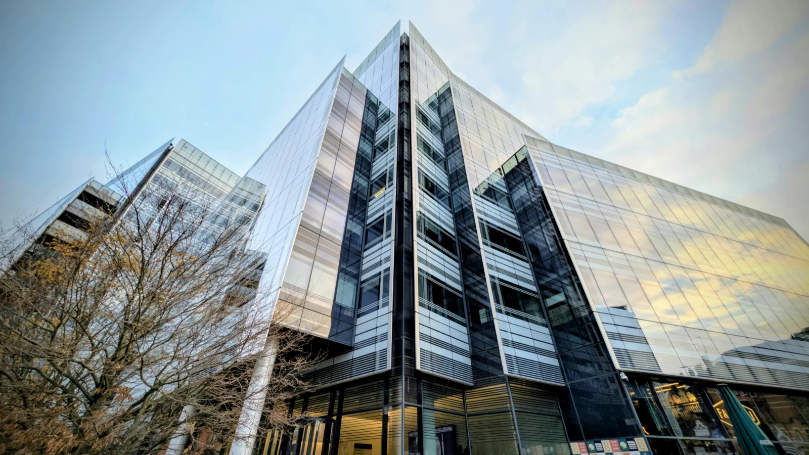 Contemporary commercial building with glass panels and steel framing under cloudy sky