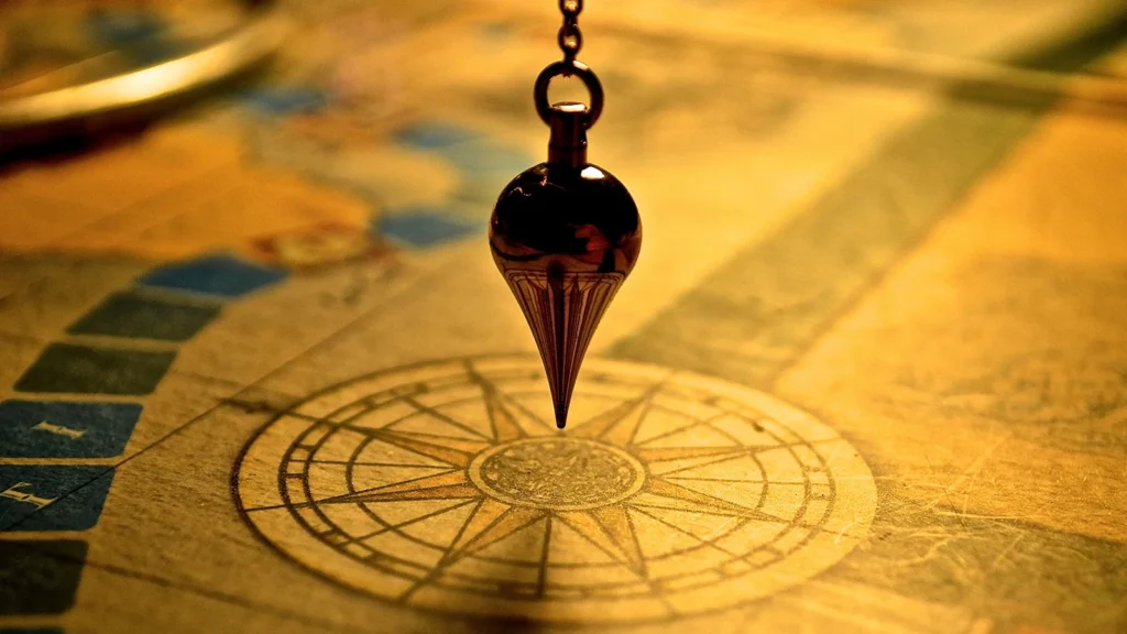 4. metal plumb bob hanging over compass rose printed on vintage map