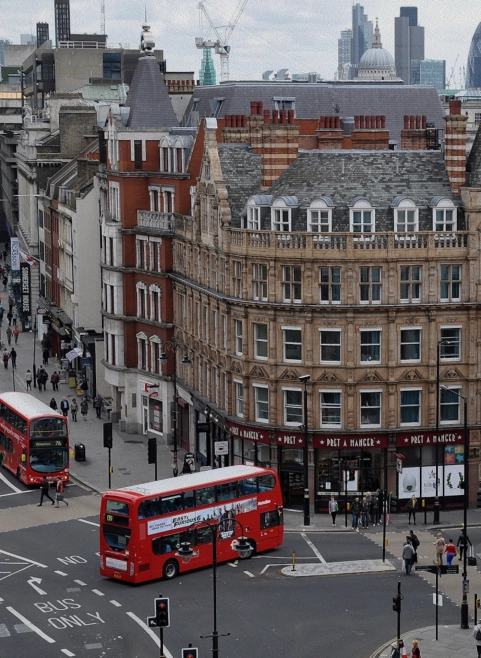 Aerial view of a London street junction with red double-decker buses and period city buildings