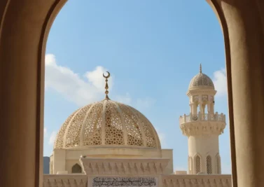 Mosque dome and minaret framed by an arch in Oman